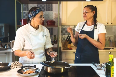 Patricya Santiago orientando uma funcionária durante uma etapa do treinamento culinário.