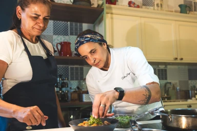 Patricya Santiago acompanhando de perto a execução de técnicas culinárias por uma funcionária.