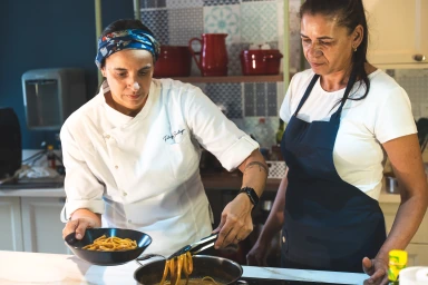Patricya Santiago acompanhando uma funcionária durante o preparo de alimentos.